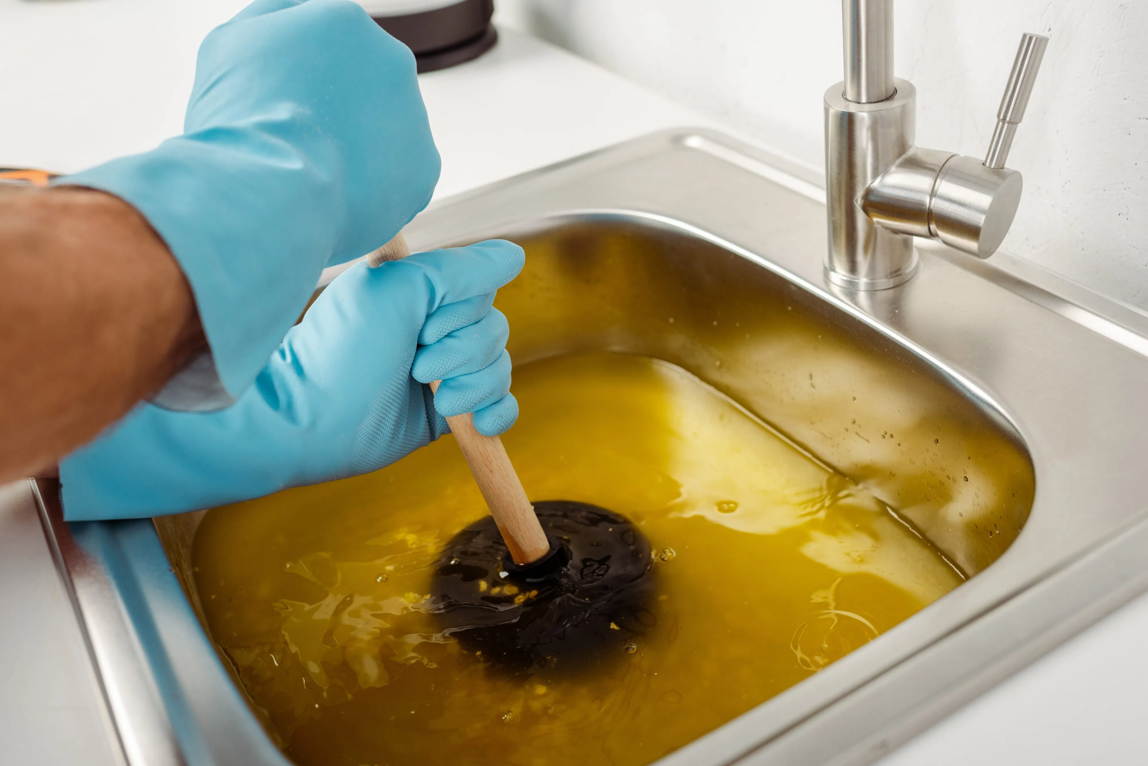 cropped-view-of-plumber-in-rubber-gloves-holding-min